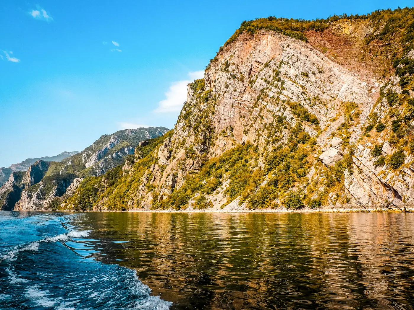 Passenger ferry crossing the narrow Komani Lake gorge in morning light