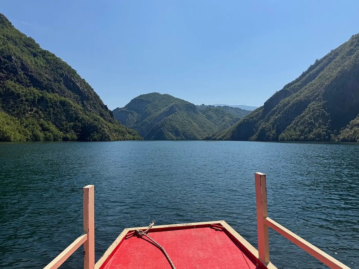 Passenger ferry crossing the narrow Komani Lake gorge in morning light